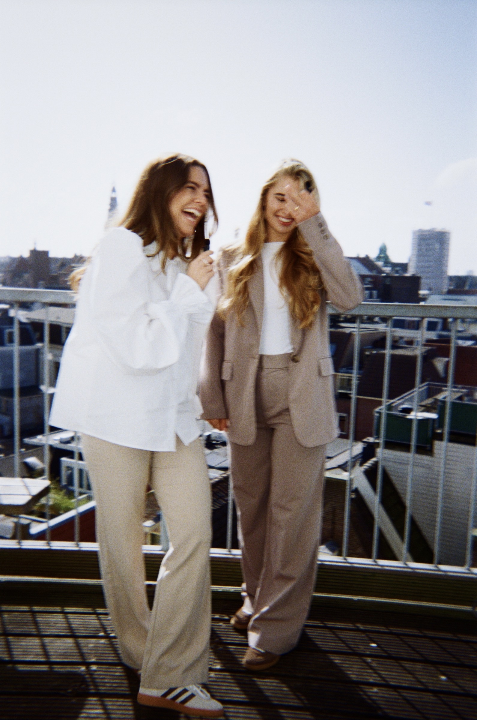 Two colleagues laughing on a rooftop terrace